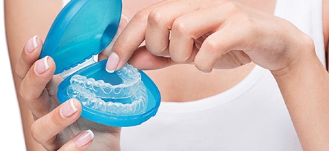 a woman holding 3d printed dental molds