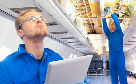 2 men working on the interior of an aiplane