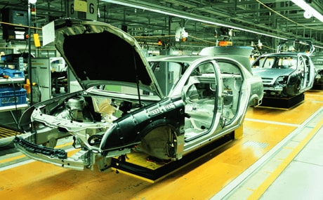 An auto manufacturing assembly line with a car being put together