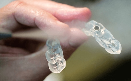 A person holding a 3D printed dental mold